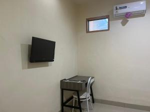 马卡萨SPOT ON 93022 Anugrah Homestay Syariah的客房设有水槽和墙上的电视