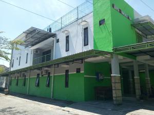 LaweanOYO 93012 Griya Kencana Asri Syariah的带阳台的绿色白色建筑