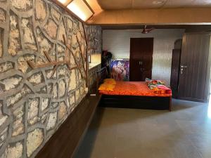 NānodraGreenescape villa at Kensville Golf living的一间卧室设有石墙,配有一张床
