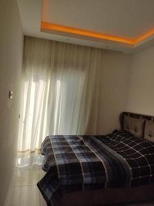 马赫姆拉Квартира в прекрасном комплексе的一间卧室配有一张带铺着地毯的床和窗户。