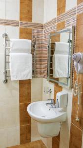 文尼察Hotel Status的浴室配有盥洗盆、镜子和毛巾