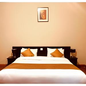 帕罗Hotel Dorjiling的一间卧室配有一张带橙色枕头的大床