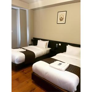 帕罗Hotel Dorjiling的酒店客房,配有两张带白色床单的床