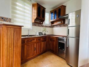 长滩岛艾萨托海滩度假村的厨房配有木制橱柜和不锈钢冰箱。