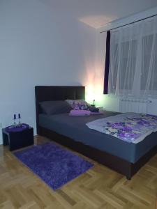皮罗特Apartman Mančić的一间卧室配有一张床和紫色地毯
