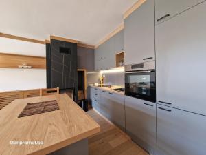 亚霍里纳Sun&Snow Jahorina的厨房配有白色橱柜和木桌