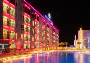 巴厘巴板Pentacity Hotel Balikpapan的一座酒店大楼,晚上设有游泳池