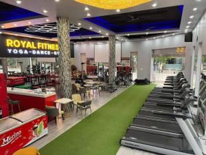 Móng CáiRoyal Homestay - Royal Center的餐厅设有健身房,铺着绿色地毯