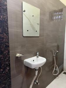 浦那Hotel Laxminarayan Niwas的浴室设有水槽和墙上的镜子
