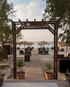 蒂加基阿克缇蒂密斯酒店的海滩上的木板路,配有桌子和遮阳伞