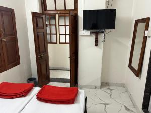 浦那Hotel Laxminarayan Niwas的客房设有两张床和一台平面电视。