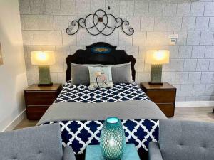阿赫瓦尼Quail Suite HOT TUB BBQ Sleeps 2的一间卧室配有一张带两盏灯的床和一张沙发。