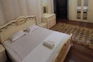 阿拉木图Almaty guest house的一间卧室配有一张白色床、梳妆台和镜子