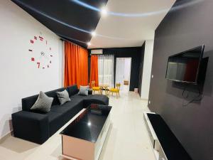 马哈赞加New Park Resort的客厅配有黑色沙发和时钟