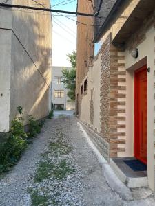 久姆里Appartment in the city center的两座建筑之间的一条小巷,有红门