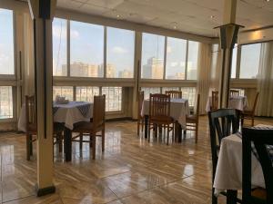 开罗假日快捷酒店的用餐室配有桌椅和大窗户