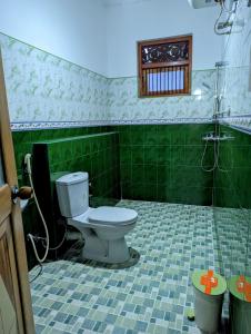 康提Moon Water's Edge的一间带卫生间的浴室和绿色瓷砖地板。