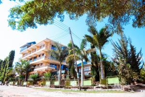 姆万扎Port Park Hotel的棕榈树海滩上的一座建筑