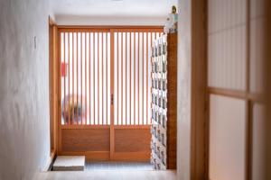 直岛町Naoshima Juju Art House　直島ジュジュアートハウス的走廊上设有一扇带窗户的木门
