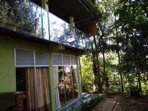 代尼耶耶Sinharaja Kurulu Ella Eco Resort的房屋设有带窗户和树木的阳台