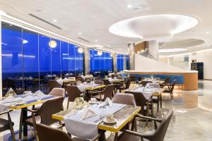 波托什Alexandra Elegance Bridging Generations的餐厅设有桌椅和蓝色的墙壁