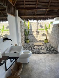 Nosy KombaCanopee Lodge的浴室配有白色卫生间和盥洗盆。