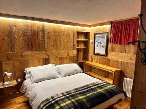 库马约尔Chalet Meyen - Val Ferret的一间卧室设有一张床和木墙