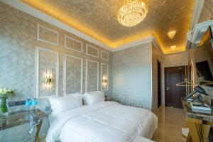 哥打京那巴鲁Ritz Residence @ Imago Loft B 7th Floor的卧室配有一张白色大床和吊灯。