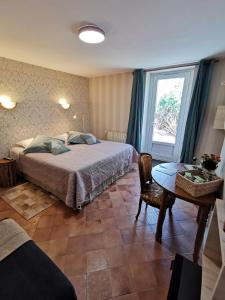 肖蒙索卢尔La Jacquière的一间卧室配有一张床、一张桌子和一个窗户。