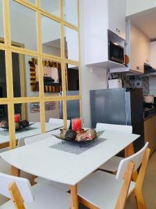 马尼拉1 Br CONDO Vine Residences Quezon City with POOL NETFLIX WIFI VIDEOKE BOARD GAMES的厨房里配有白色的桌椅