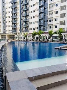 马尼拉1 Br CONDO Vine Residences Quezon City with POOL NETFLIX WIFI VIDEOKE BOARD GAMES的一座大型游泳池,位于部分建筑前