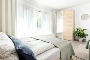 坡道旁盖斯林根Apart4me Scandi Apartment Geislingen zentral mit Parkplatz的一间卧室设有一张床和一个大窗户