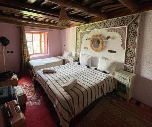 伊姆利尔Berber Family Lodge的一间卧室设有两张床,墙上设有一面镜子