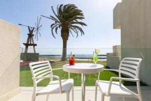 科斯塔特吉塞HD海滩度假酒店的一个带桌椅和棕榈树的庭院