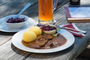 奥夫塞斯Brauereigasthof Rothenbach的木桌上的一盘食物和饮料