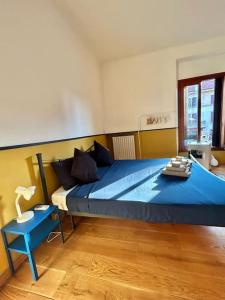 米兰MenabreaFlat- 10 min to Centrale的一间卧室配有一张带蓝色床单的大床和一张桌子