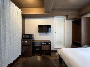东京Cozy inn Oyama的一间卧室配有一张床和一张带微波炉的书桌