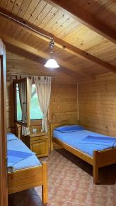 圣金Kompleksi Turistik Leonardo的木墙客房的两张床