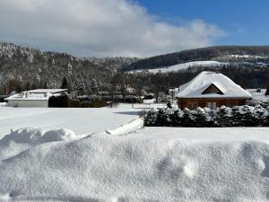 巴利格鲁德Domek na Słonecznym Pagórku的一堆积雪覆盖的房子