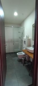 OmaloGuest House Shina的浴室配有卫生间、盥洗盆和淋浴。