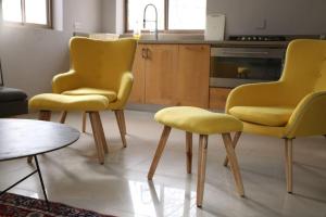 Kefar DaniyyelLahav Suite的厨房配有2把黄色椅子和桌子