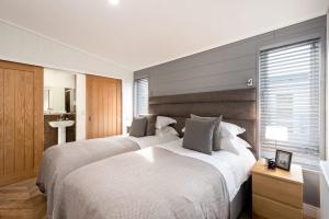 布里奇诺斯Shropshire Lodges - Romantic Luxury Hot Tub Breaks的一间卧室设有两张床和窗户。