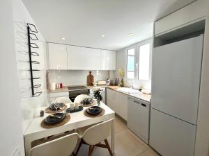 瓦伦西亚Luxury Apartment Valencia Center的厨房配有白色橱柜和桌椅
