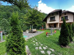 里巴里卡Вила 11 - семейна почивка в сърцето на Балкана的一座带树木庭院和游乐场的房子