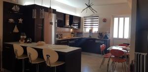 纳夫普利翁villa strati的厨房配有蓝色橱柜和桌椅
