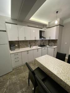 尼代Firuze Park的厨房配有白色橱柜和桌椅