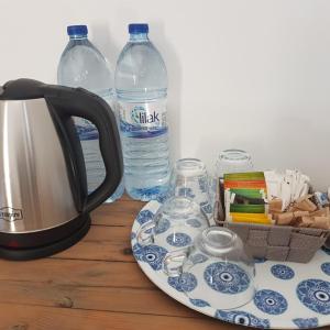 北尼科西亚Sabor Residence的茶壶、茶杯和桌子上的瓶装水
