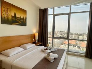 拉马拉Caesar Hotel Ramallah的一间卧室设有一张大床和一个大窗户