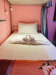 琅勃拉邦DownTown Backpackers Hostel的两条毛巾,看起来像天鹅坐在床上