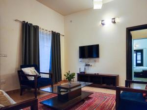 莫尔吉姆Beach Villa Morjim的客厅配有沙发和墙上的电视